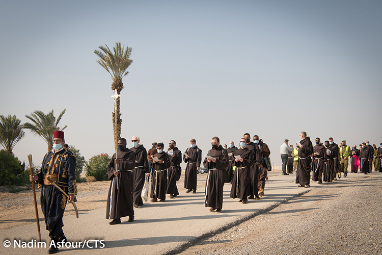 Alter servers walk down the path during an outdoor mass