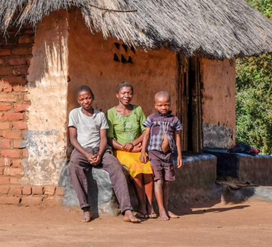 Sadzuri Kamoyo sits on a wall with her two sons