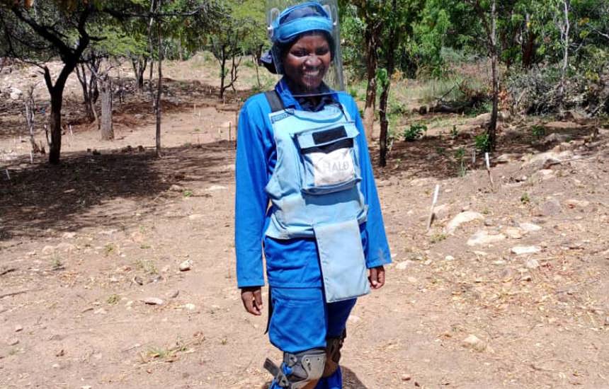 Delight Manyange, GIS Specialist, wears HALO uniform and PPE in a minefield in Zimbabwe