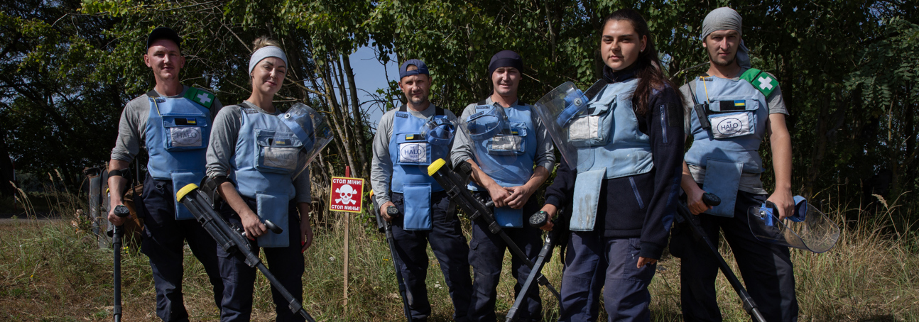 Demining team, in Zolotynka Village, Chernihiv oblast, pose in a minefield with their metal detectors