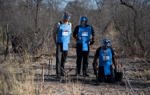 Prince Harry watches a demonstration by HALO Trust deminers whilst wearing PPE