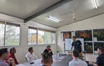 A HALO staff member leads a meeting with colleagues and representative Ami Bera sitting around a table