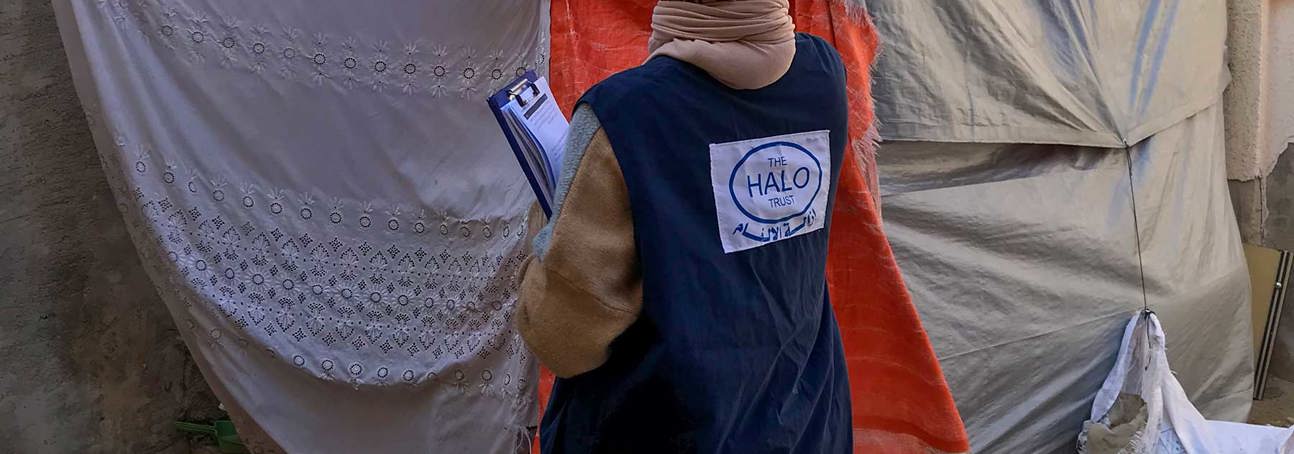A HALO staff member stands in front of sheets covering the doorway into a building