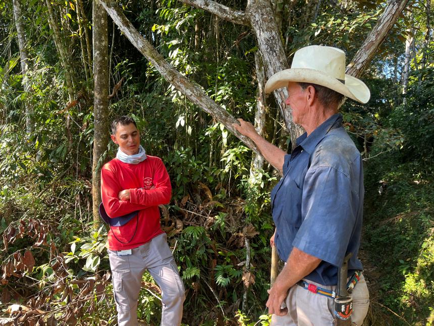 A Colombian HALO staff member speaks with a man wearing a hat outside