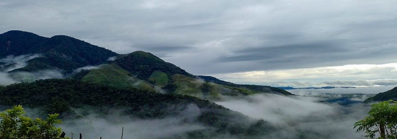 A scenic view of mountains peaking above the clouds in Ondas del Cafre