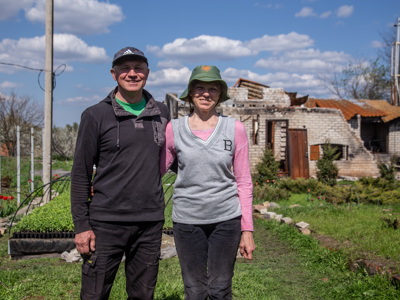 Natalia and Vyacheslav, a couple from Kharkiv, stand with their arms linked in their backyard 