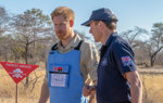 Prince Harry and HALO Trust CEO, James Cowan, walk through a minefield in Angola wearing HALO Trust uniform