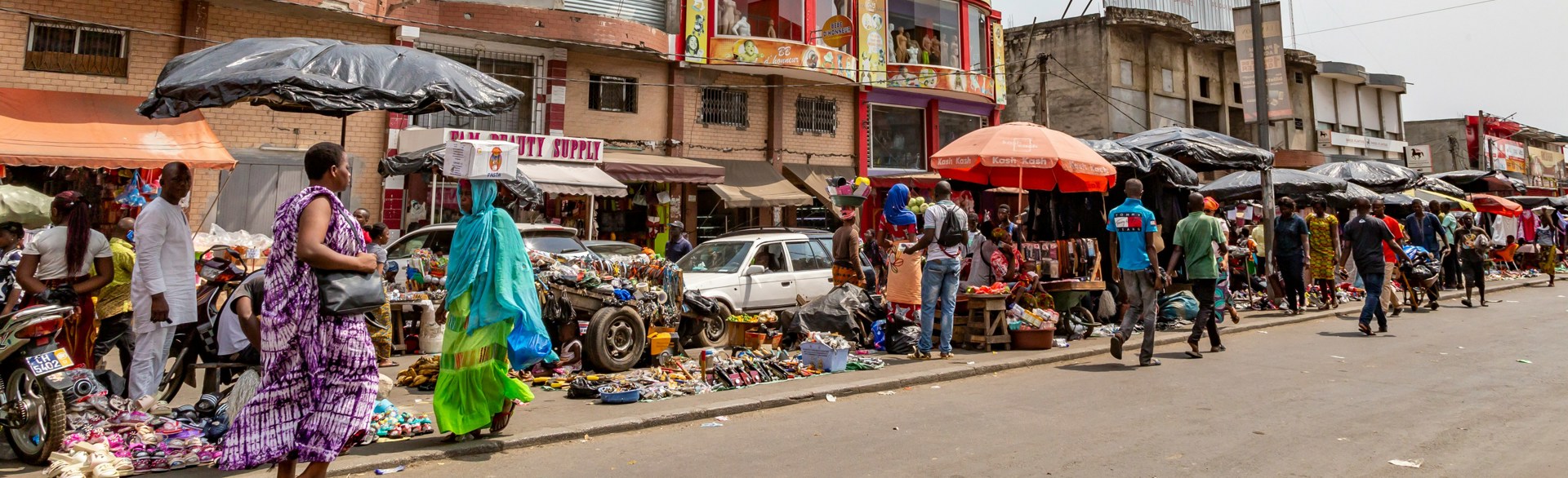 People walking along a street market in Cote d'Ivoire