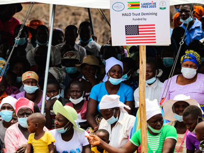 Locals gather together with a US funded landmine free sign