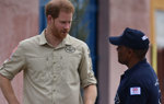 Prince Harry talks with a HALO Trust staff member wearing a HALO Trust shirt in Huambo, Angola