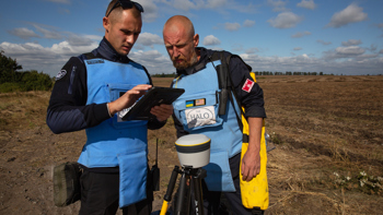 HALO staff work with a Trimble device on a minefield
