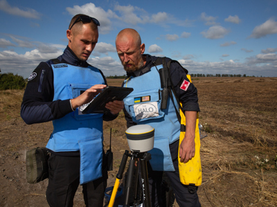 HALO staff work with a Trimble device on a minefield