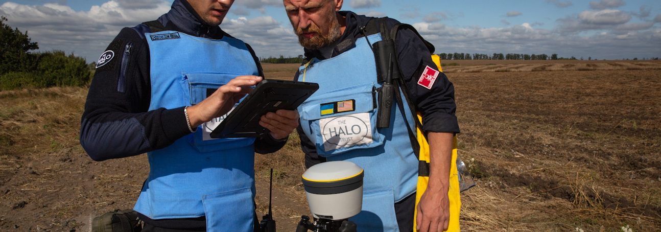 HALO staff work with a Trimble device on a minefield