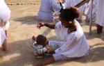 A child is baptised during the Epiphany celebrations in the Jordan River
