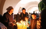 Children and adults gather to light candles at the Baptism Site