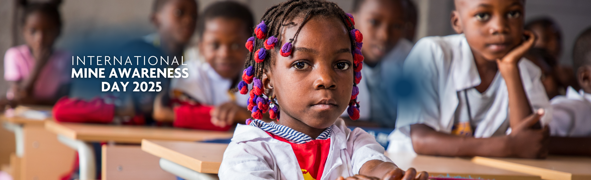 A child sits behind her desk in a classroom