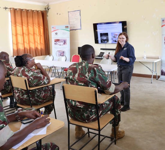 Military personnel sit in a weapons management class
