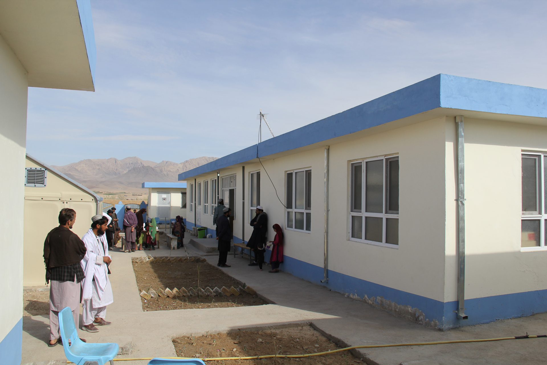 A group of people wait outside Yaklinga Clinic in Haji Ismail village, Uruzgan