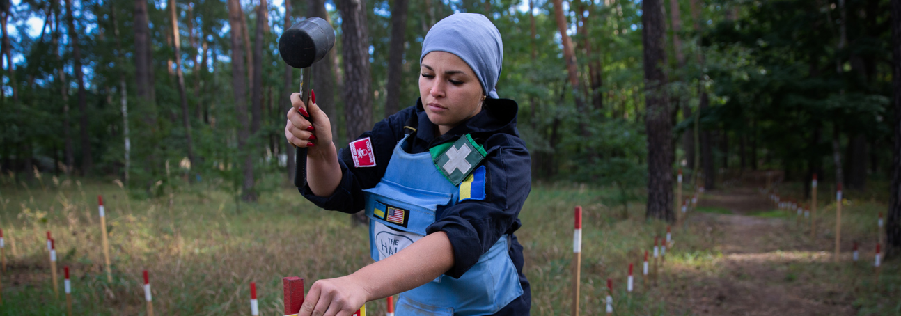 HALO deminer Karina at work putting up danger signs