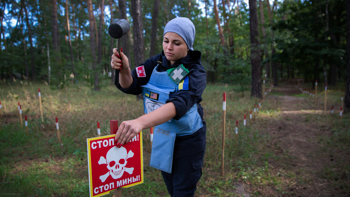 HALO deminer Karina at work putting up danger signs