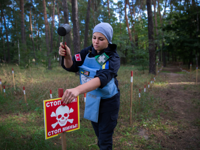 HALO deminer Karina at work putting up danger signs